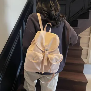 Sac à dos minimaliste en nylon beige avec deux poches avant et boucles magnétiques