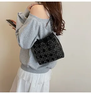 Detalle de bolso saco negro de strass con cadena plateada y cordones suaves