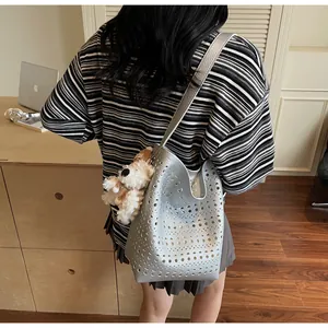 Close-up of a silver hollow-out bucket bag with a cute white plush puppy pendant