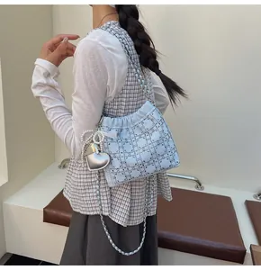 Detalle de bolso saco acolchado azul claro con textura de diamantes de imitación