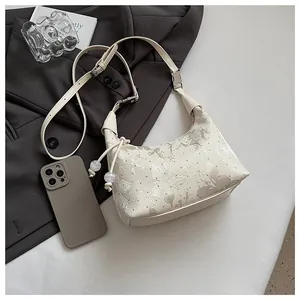 Close-up of cream crossbody bag with silver marble print and decorative clear beads