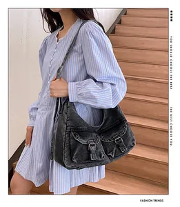 Détail du sac hobo en jean délavé vintage avec boucles métal et poches cargo