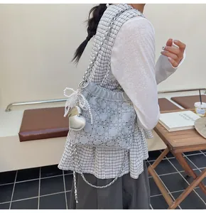 Detalle del bolso de cubo azul con diamantes de imitación, lazo de perlas y corazón