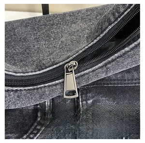 Détail du zip métallique sur un grand sac cabas en denim noir délavé vintage
