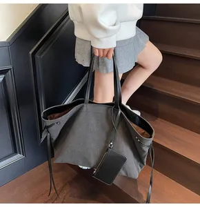 Detail of dark charcoal canvas tote bag featuring leather straps and a side drawstring