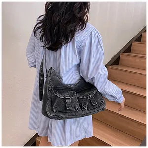 Détail du grand sac fourre-tout en denim noir délavé avec poches avant et boucles en métal