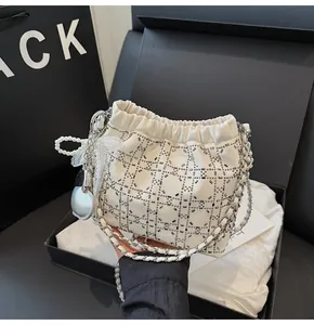 Detalle del bolso de strass blanco con asa de perlas y lazo de encaje suave