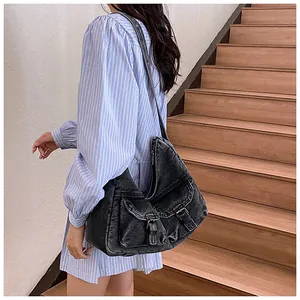 Gros plan sur un sac cabas en denim noir délavé avec poches avant et détails de boucles
