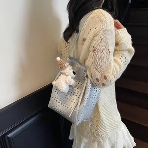 Silver laser hollow-out bucket bag with plush dog charm and long shoulder strap
