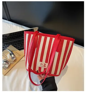 Détail du grand sac cabas à rayures rouges et blanches avec texture et logo daxi
