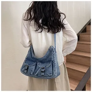 Gros plan d'un sac cabas en jean bleu délavé avec poches porté par un mannequin