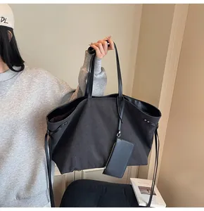 Detail of black canvas tote bag with side drawstring and matching zipper coin purse accessory