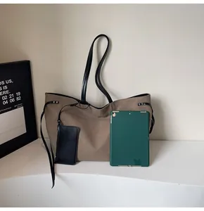 Detail of earthy tote bag with thin leather straps and a matching black sub-bag