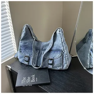 Détail du grand sac cabas en denim bleu avec poches cargo et boucles en métal argenté