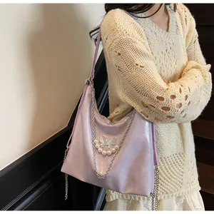 Close-up of lavender tote with silver butterfly, pearls, and glossy wrinkled texture