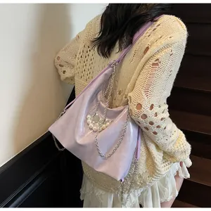 Detail of light purple tote bag with silver chains and pearl butterfly charm on model