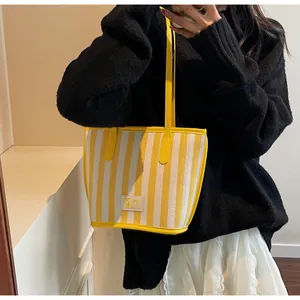 Détail du sac cabas à rayures jaunes avec poignées en cuir et texture du textile
