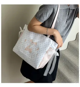 Détails de broderie lapin et nœud en dentelle sur le sac fourre-tout à pois roses