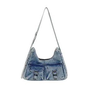 Grand sac cabas en denim bleu délavé avec deux poches avant et boucles en similicuir noir