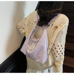 Macro detail of lavender glossy tote bag with silver butterfly and pearl chain strap