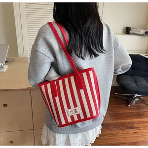 Détail du sac fourre-tout à rayures rouges et blanches avec étiquette de marque