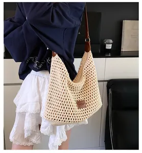 Dettaglio borsa da spiaggia all'uncinetto beige con spalline in pelle marrone
