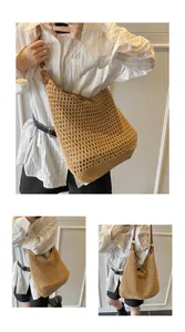 Dettaglio borsa hobo a rete traforata con trama in paglia e tracolla in pelle marrone