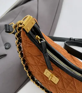 Dettaglio borsa trapuntata in camoscio marrone con cerniera dorata e finiture in pelle