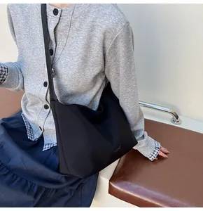 Close-up of a black nylon bucket bag with a Classic label, shown on a model's shoulder