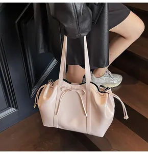 Rosafarbene Lackleder-Tragetasche mit Schleife und Kordelzug auf der Treppe