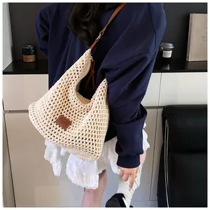 Dettaglio della borsa a spalla in maglia traforata con tracolla e patch in pelle marrone