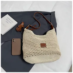 Dettaglio della borsa a tracolla intrecciata beige con cinturino in pelle e trama crochet