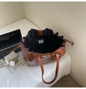 Detail der dunkelbraunen Tragetasche mit Magnetverschluss und Reißverschlussfach