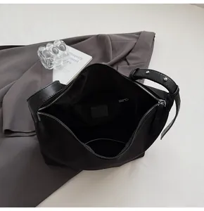 Detail view of the black bucket bag's interior compartment with a zippered pocket