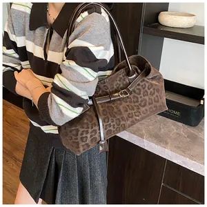 Dettaglio della borsa tote leopardata marrone scuro con manici in pelle e fibbia