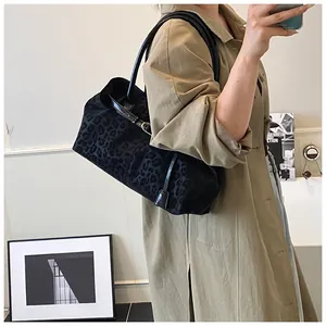 Dettaglio della borsa tote leopardata nera con fibbia dorata indossata dalla modella