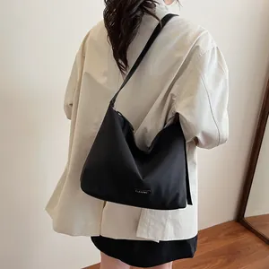 Minimalist black nylon bucket shoulder bag for women with clear K brand logo