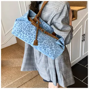 Borsa tote con stampa leopardata blu e cinturini in pelle marrone indossata da modella