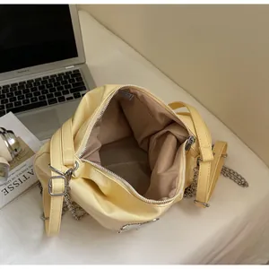 Detail of yellow patent leather tote interior with chain strap and spacious main pocket
