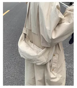 Détail d'un sac à bandoulière en daim beige minimaliste avec une grande capacité de stockage