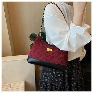 Dettaglio borsa hobo trapuntata rosso vino con catena dorata e chiusura a rotazione