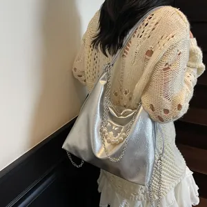 Silver metallic tote bag with pearl butterfly accent shown on model in stairwell