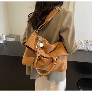Grand sac cabas marron en daim porté en bandoulière avec pendentif de baseball sur mannequin