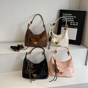 Elegante borsa hobo in pelle scamosciata con logo in metallo e perla ambrata in vari colori