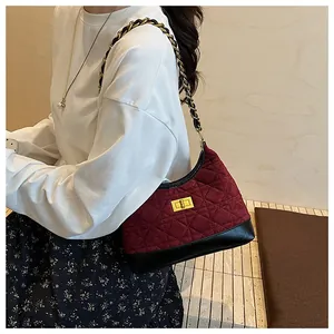 Dettaglio borsa trapuntata rossa in velluto con finiture in pelle e catena oro