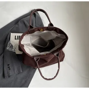 Vue intérieure du grand sac cabas en daim avec fermeture magnétique et poche zippée