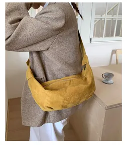 Gros plan détaillé d'un sac demi-lune en daim jaune moutarde avec fermeture éclair