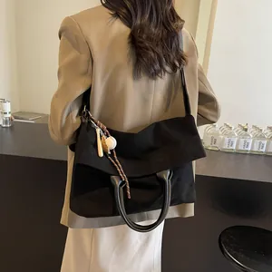 Grand sac cabas noir en suédine avec breloque sport, idéal pour le quotidien