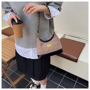 Dettaglio del tessuto trapuntato beige e pelle nera con chiusura a scatto dorata