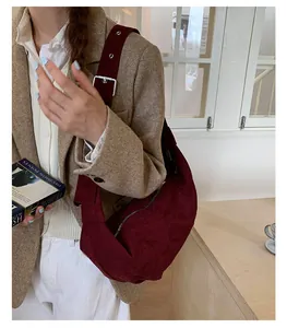 Détail du sac hobo en daim bordeaux avec large bandoulière et boucle en métal argenté